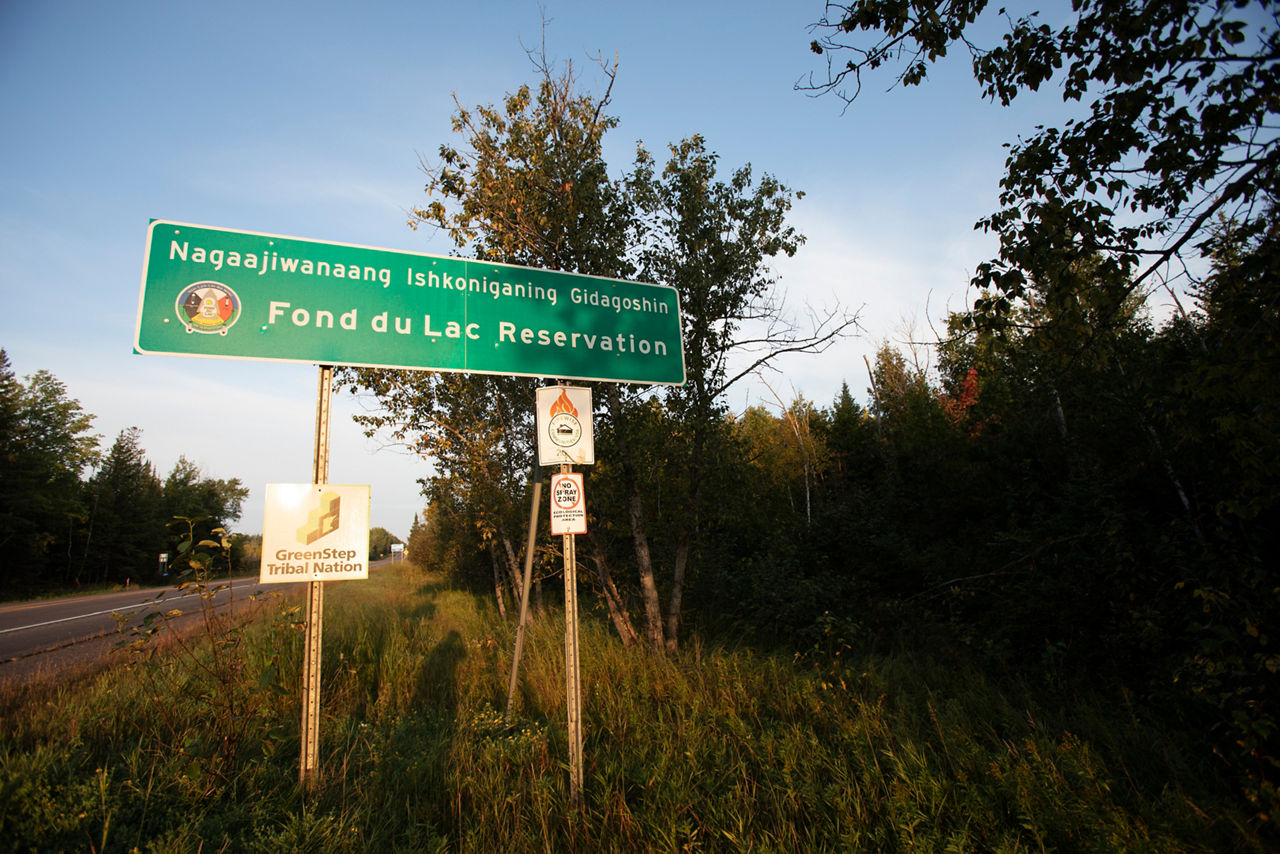 A  road sign featuring two languages on the side of the road.