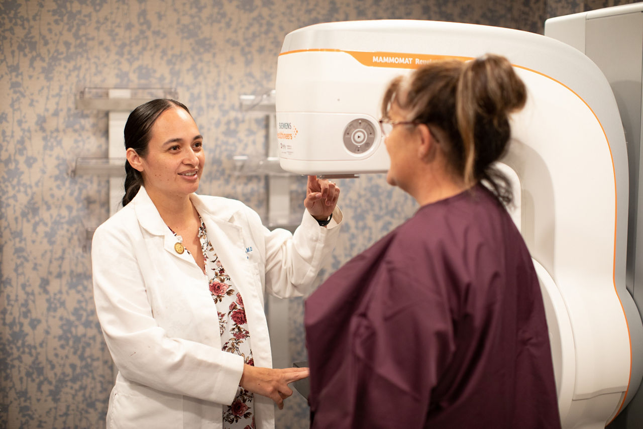 Chairty Reynolds (right) is a full-spectrum family medicine physician and the medical director for Fond du Lac Human Services Division. She is pictured here inside the Min No Aya Win (Human Servces Center) explainig the mammogram device available at their health center. The mission of the Fond du Lac Human Services Division is to elevate the health and social well-being of American Indian people living in the service area through the provision of culturally appropriate services, research, education and employment opportunities.