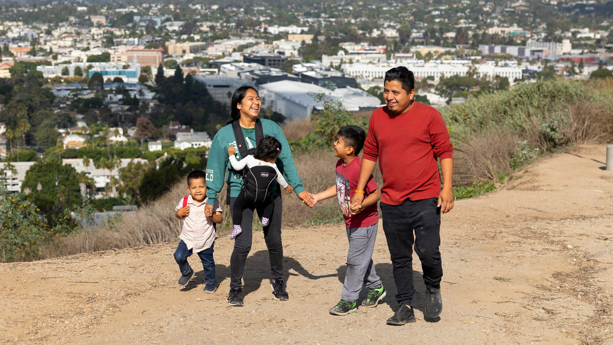 A family of five hikes outside at the Baldwin Hills Scenic Overlook Trail in Los Angeles, California.