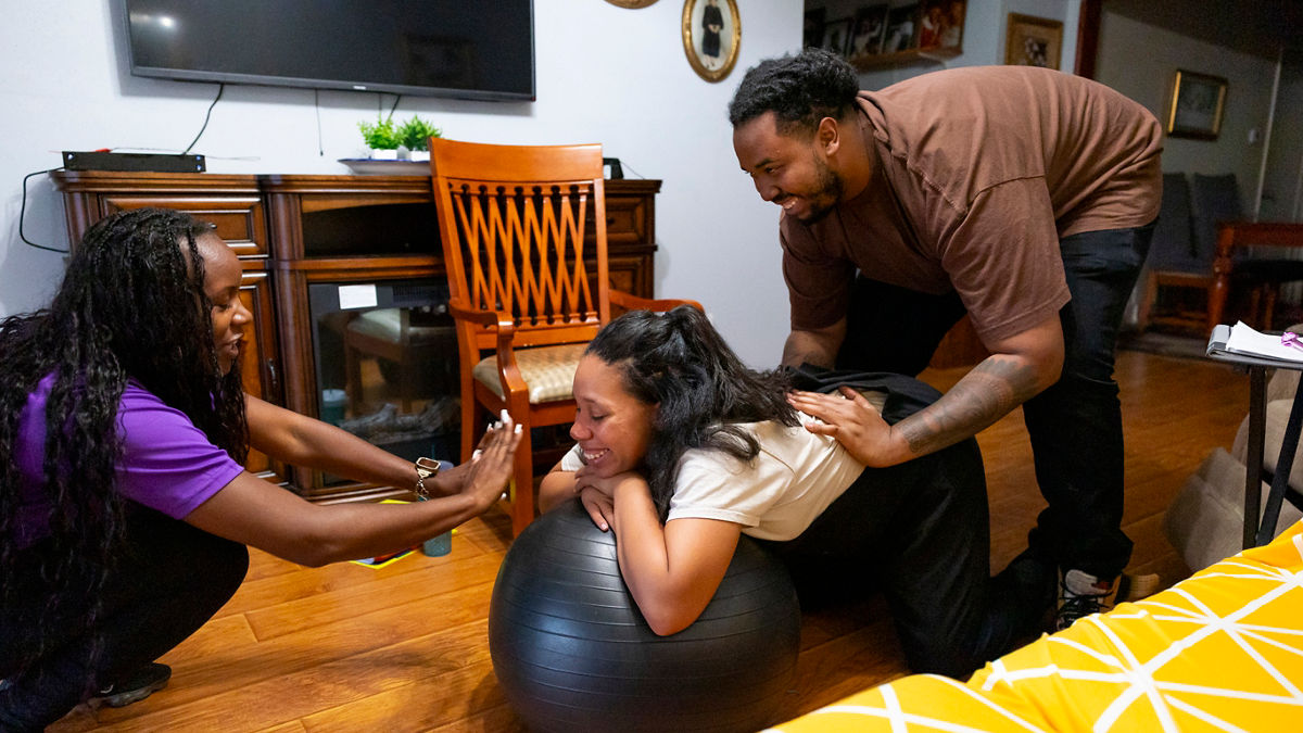 Expecting parents Sarah Hamilton and Carl Vance III meet with their doula Lakeisha Solomon at their home in South Los Angeles, California on October 23, 2023. Lakeisha teaches Carl how to do "hip squeezes" to help Sarah manage pain during labor.