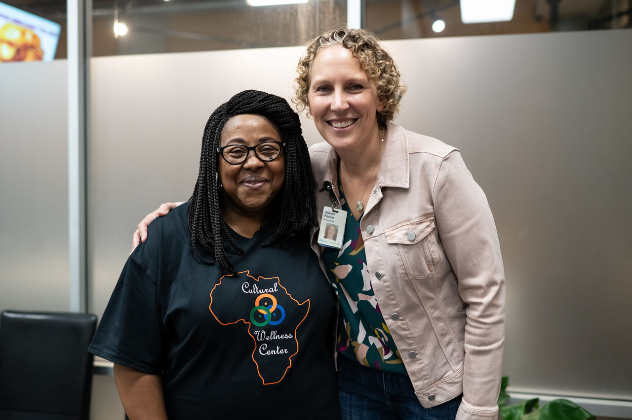 Two women standing together in an office.