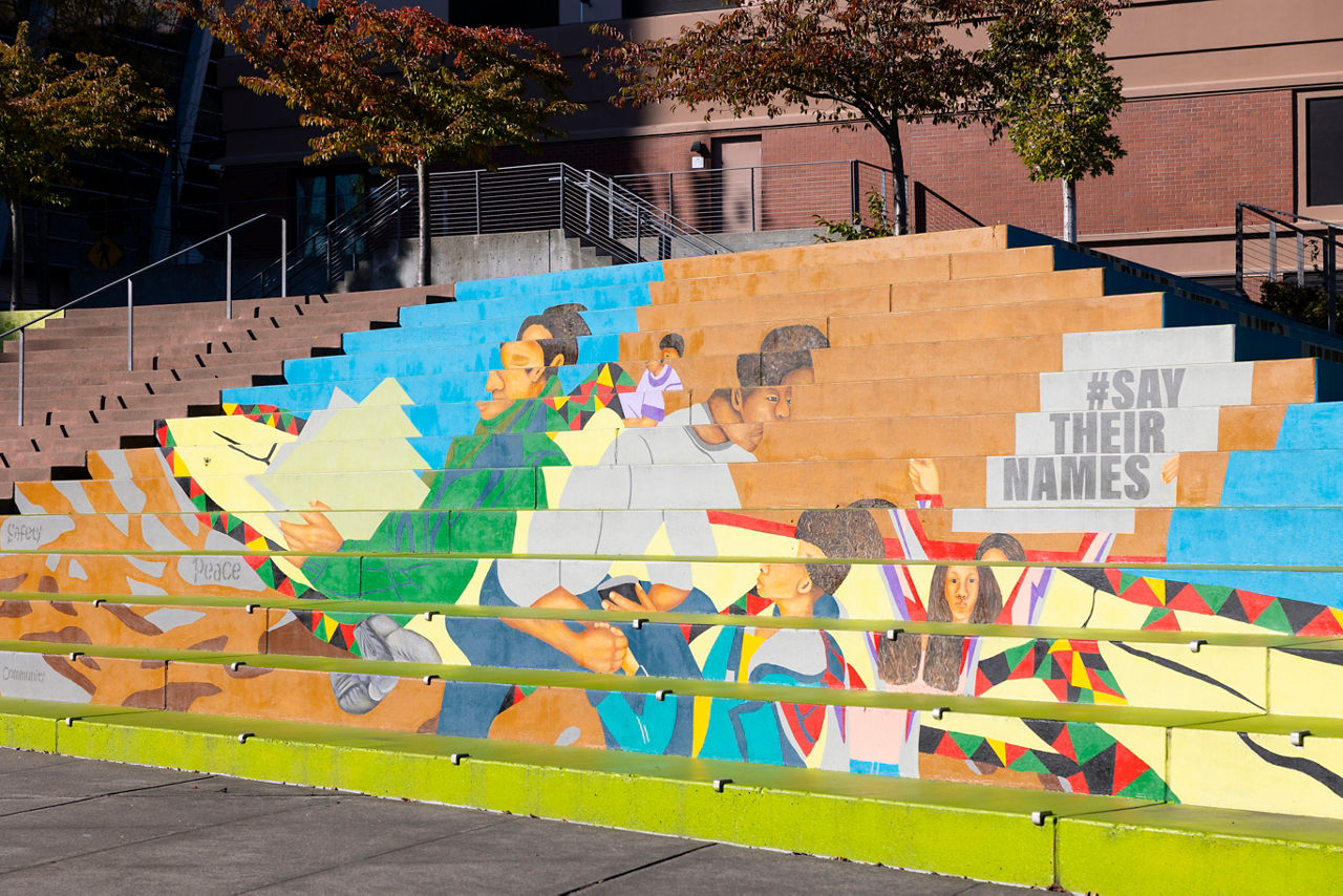 A colorful mural on a large staircase including the hashtag #saytheirnames. 