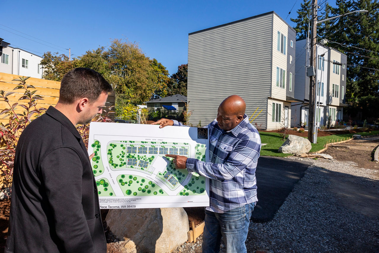 One person presents a map depicting neighborhood housing units.
