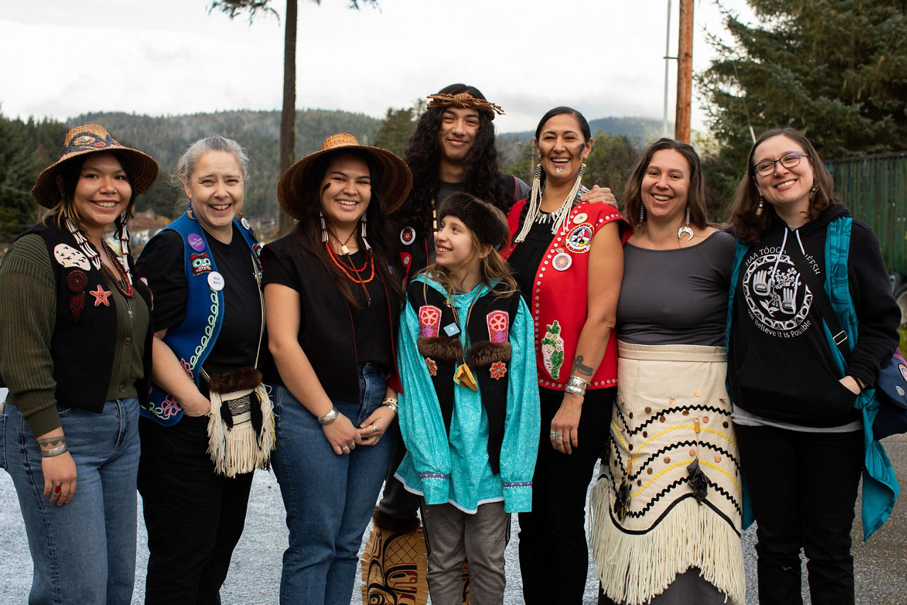 (L-R) Corinne James, Renee Culp, Markayla Katchatag, Keagan Hasselquist, Bodhi Nasiah, Jamiann Hasselquist, Ati Nasiah, and Thomasina Andersen attend a Ku.éex' (Tlingit ceremony) held in Angoon in October 2024, during which the U.S. Navy issued a formal apology for the bombardment of the Angoon community in 1882.