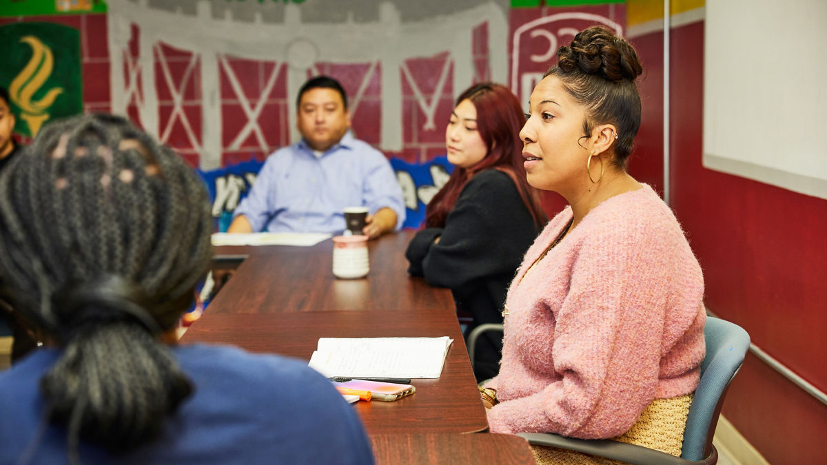 Community leaders meet at a table in their colorful office.