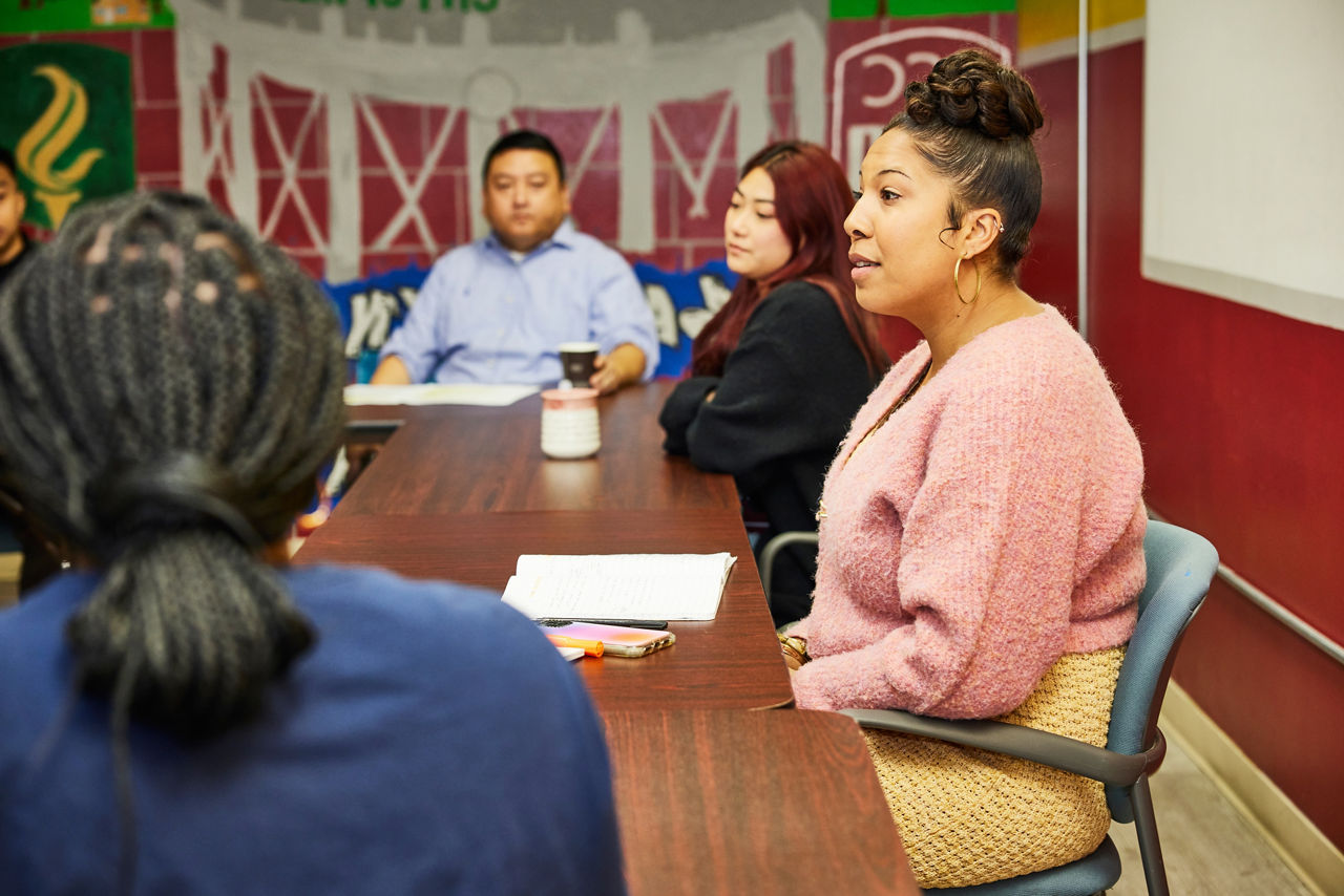 Community leaders meet at a table in their colorful office.