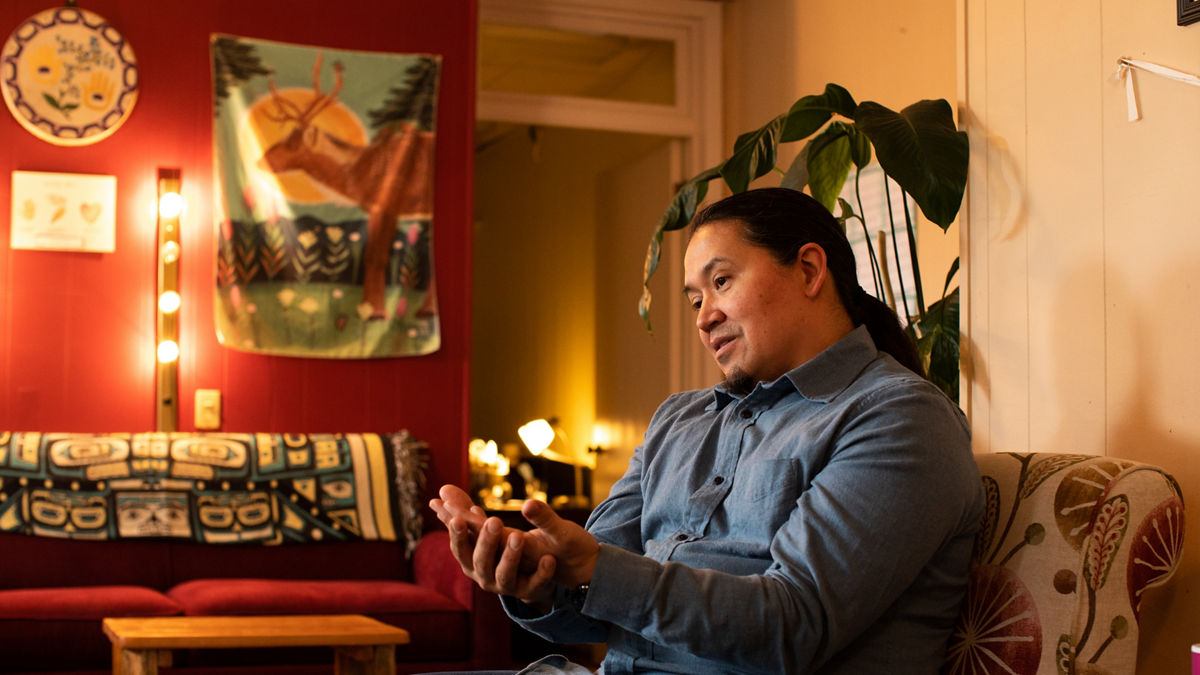 A man sits with his hands face up.