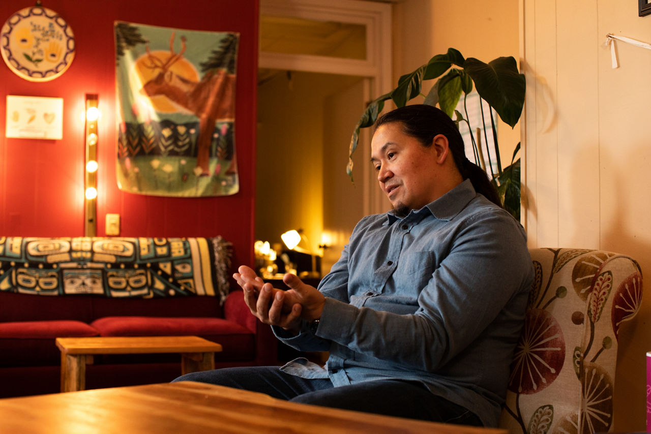 A man sits with his hands face up.