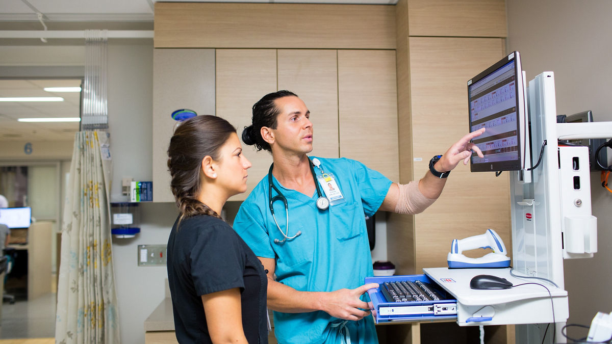 Nurses use a computer to monitor patients.