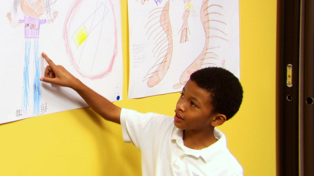 A young boy pointing to a smoking cessation poster.