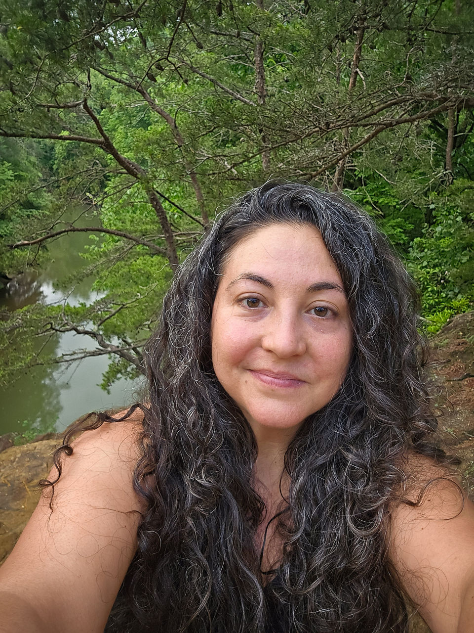 Stacey taking a selfie in front of a river.