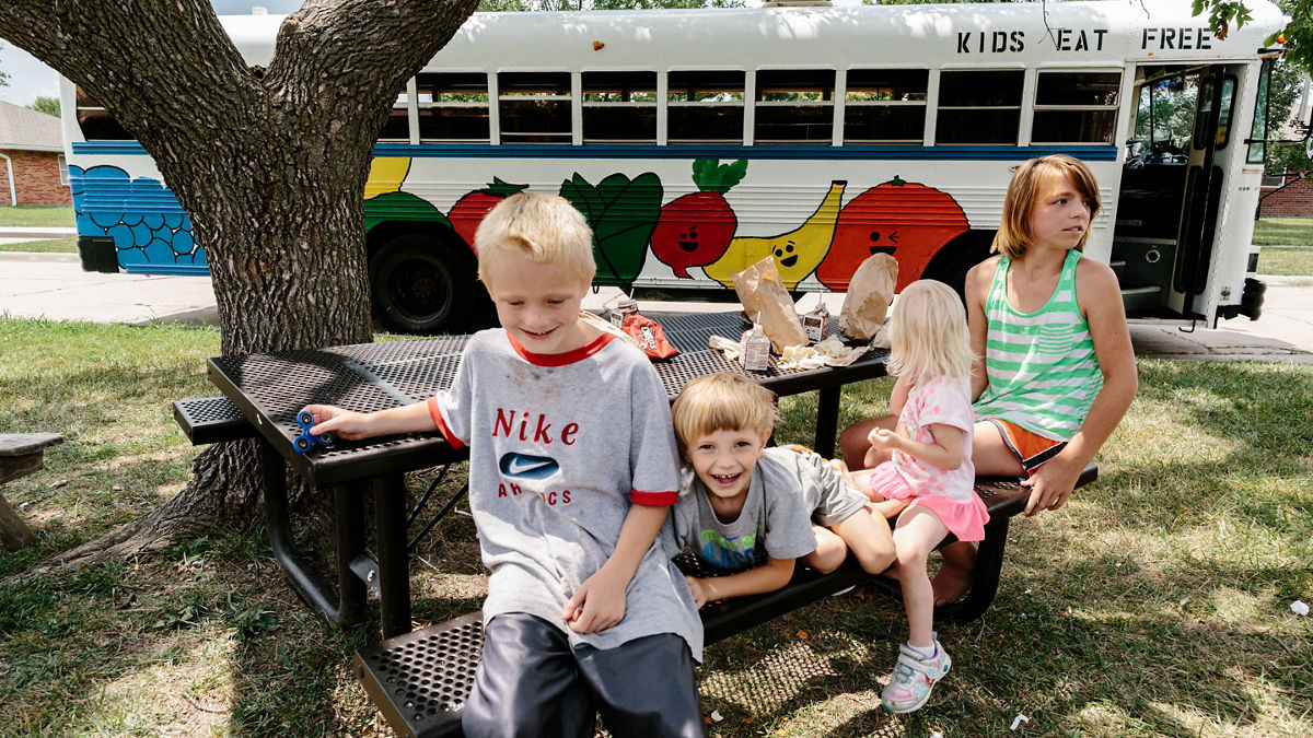 Young children enjoying lunch at a picnic table. 