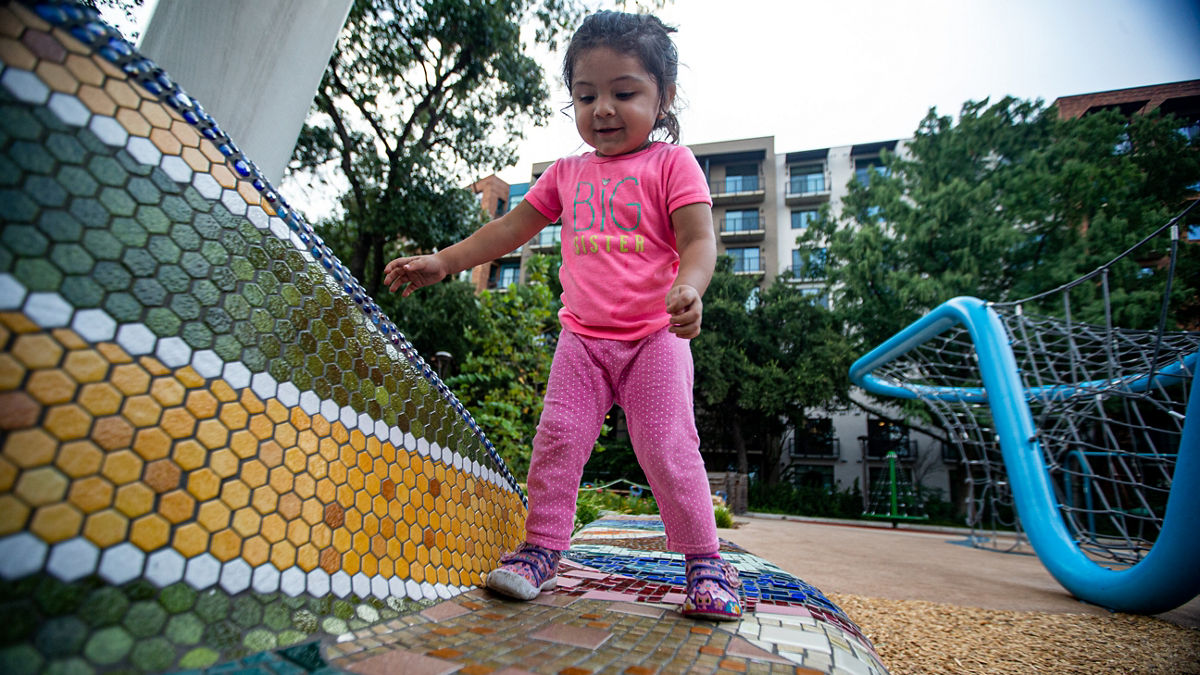 A toddler playing in a playground.