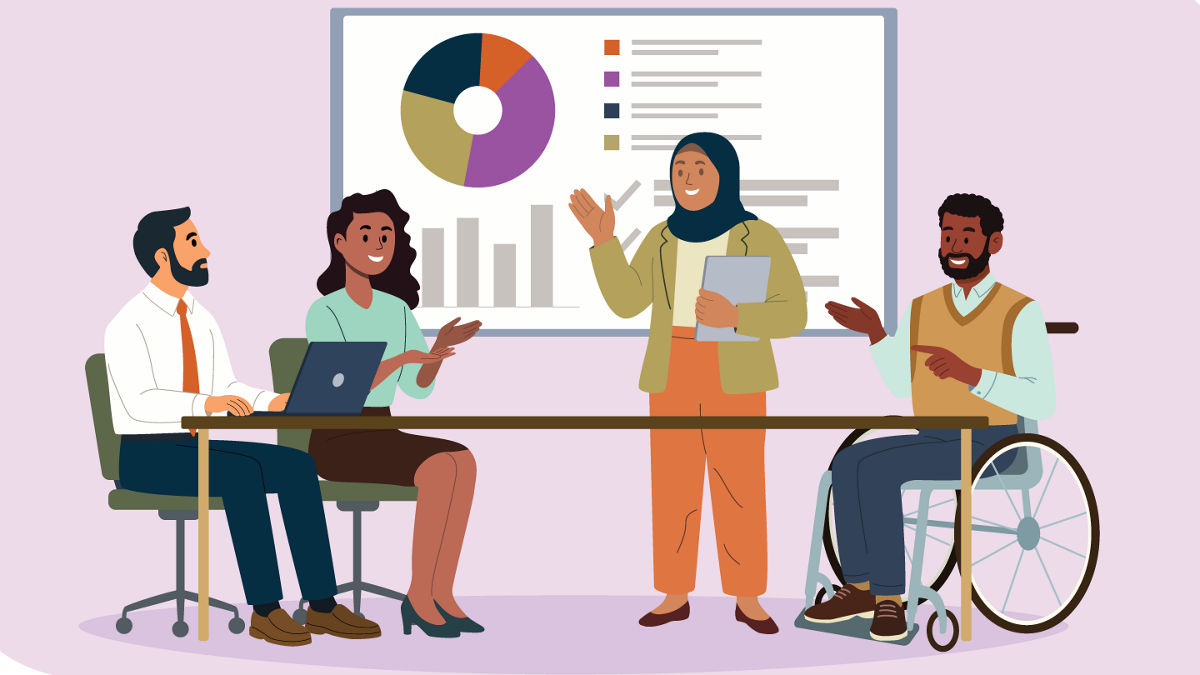 A diverse group of colleagues sit around a conference table, smiling and talking together. Behind them, a large whiteboard displays charts and notes.
