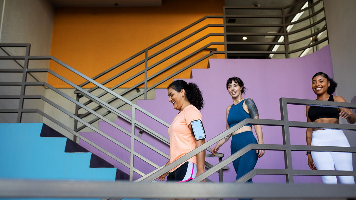 Group of multi-ethnic women walking down the stairs of gym. 