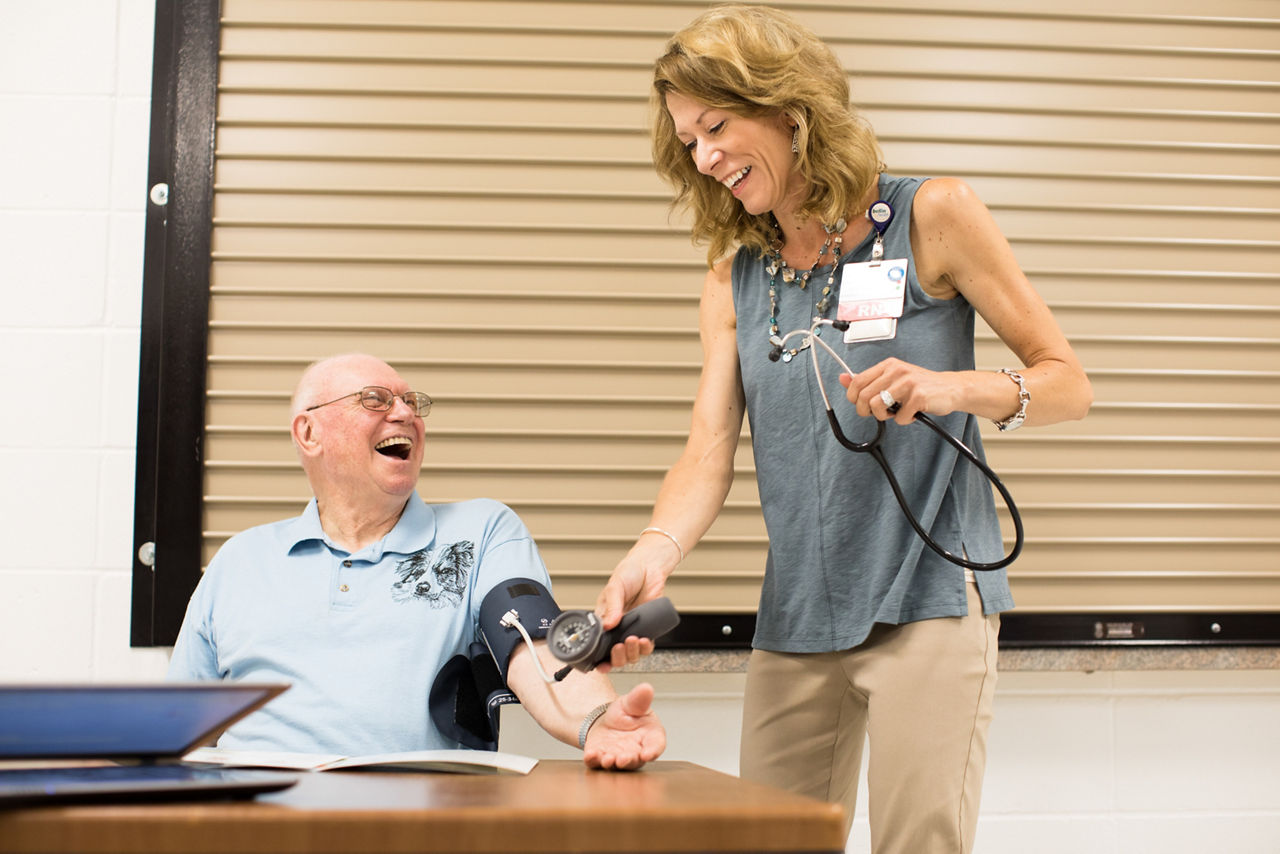 A nurse testing blood pressure at an outdoor health fair.