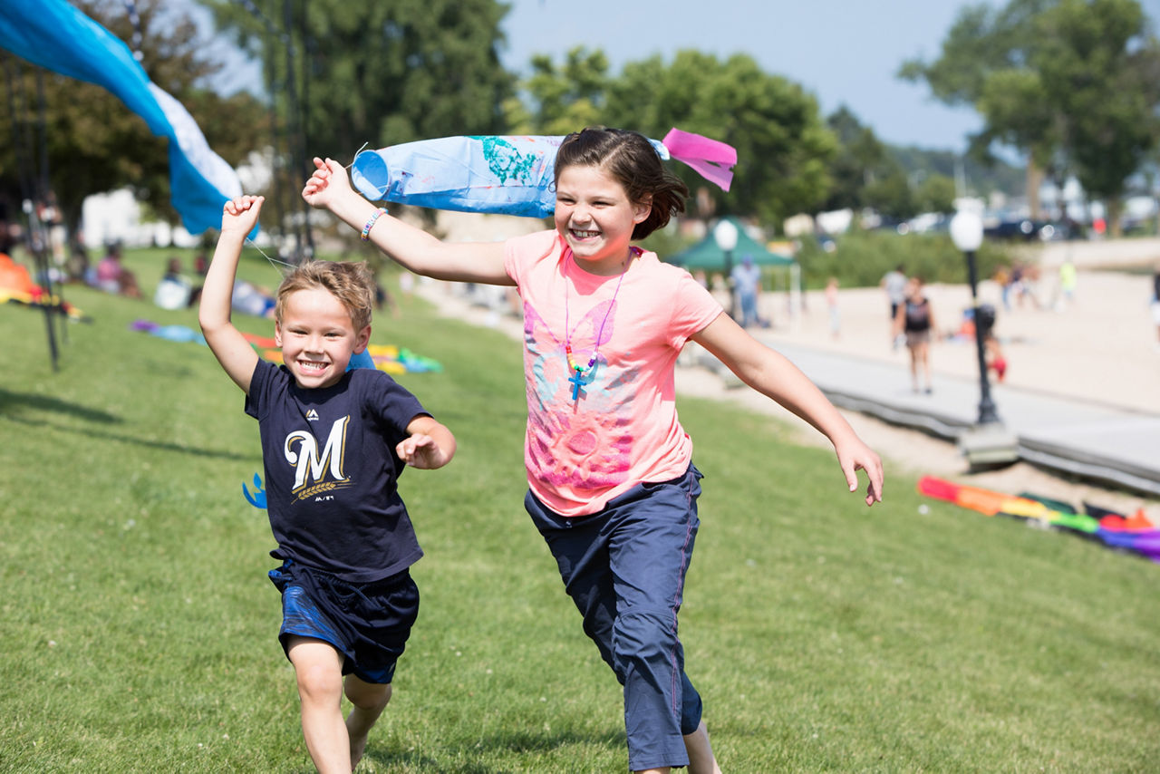 Two children running with kites.