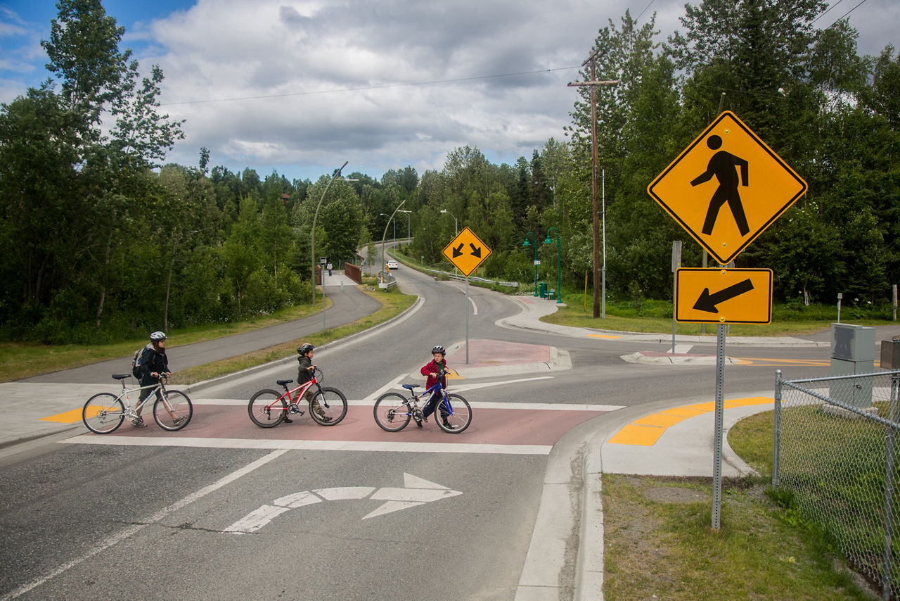 Three cyclists crossing the street. 