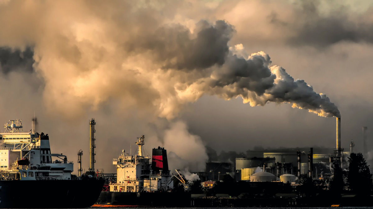 Smog billows across the sky above a shipping port.